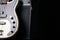 Black and white electric bass guitar with jack cable and classic amplifier