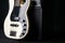 Black and white electric bass guitar with jack cable and classic amplifier