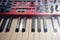 Black and white electronic piano keys  red modern synthesizer with sliders and buttons