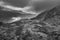 Black and white Epic Autumn landscape image of view along Nant Fracon valley in Snowdonia National Park with dramatic evening sky