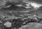 Black and white Epic moody Autumn sunset landscape image of Llyn Ogwen and Tryfan in Snowdonia National Park with stream and rocks