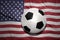 Black and white football ball on the national flag of united states of america