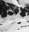 Black and white high mountains with snow cornice and avalanche tracks