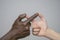 Black-and-white human hands touch fingers, representing the sign infinity. The concept of fighting racism, inter-racial