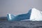 Black and white iceberg with land and foggy sky