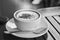 Black and white image of coffee cup and spoon in small dish