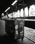 Black and white image of an old suitcase in a train station.