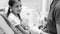 Black and white image of pediatric dentist educating little girl about teeth cleaning