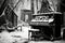 black and white image of a piano in a snowy backyard