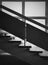 Black and white interior architecture details, old staircase by the window. Wooden railing and stone stair steps inside a shabby