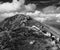 Black and white landscape of rocky mountain with flock of sheep