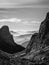 Black and white landscape view of hazy rolling mountains and hills in the Italian Dolomites at sunrise. Portrait orientation.