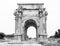 Black and white medium shot of iconic Arch of Septimius Severus at ancient Roman ruins of Leptis Magna in Libya