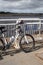 Black and white mountain bike leaning against railings at a mooring beside the edge of a river