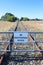 A black and white No Unauthorised Access warning sign on the fence of a closed railway line