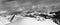 Black and white panoramic view on off-piste snow slope and cloud