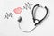 Black and white phot of toy stethoscope and colorful heart beats illustration over textured background