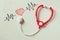 Black and white phot of toy stethoscope and colorful heart beats illustration over textured background