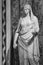 Black and white photo of ancient marble sculpture of roman woman dressed with a tunic and veil