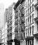 Black and white photo of buildings facades with fire escapes, New York, USA