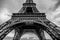 Black-white photo of close-up element part of Eiffel tower in Paris against dramatic twilight sky at evening summer time