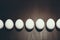 Black and white photo of the line of white Easter eggs are on the black background with mate effect and space for your text