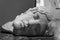 Black and white photo of male sleeping head of old marble roman statue