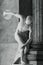 Black and white photo of marble statue of roman naked athlete throwing a discus