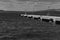 Black and white photo showing an empty port with a pier overlooking the sea and a berth for ships