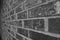 Black and white photo of a solid brick wall outside