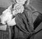 Black and white photo of a wise woman isolated at home during the quarantine coronovirus pandemic, holding a bouquet