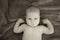 Black and white picture of baby showing his muscles