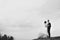 Black and white picture of newlyweds standing on the hill under