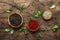 Black, white and pink rose peppers in bowls, assorted spices and spicy herbs on wooden rustic kitchen table, copy space, top view
