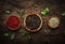 Black, white and pink rose peppers in bowls, assorted spices and spicy herbs on wooden rustic kitchen table, copy space, top view