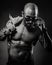 Black and white portrait brutal man with a bare torso looks from under the glasses. Studio photo. muscular body