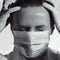 Black and white portrait of medical worker wearing mask and closing eyes because of pain