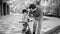 Black and white portrait of young man teaching his son driving his first bicycle