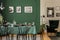 Black and white posters on wall of stylish dining room interior with log table with wine glasses, plates and cones