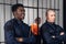 Black and white prison guards stand with batons in the background of cells with prisoners criminals.