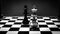 Black and white shot of the confrontation between white and black chess pieces standing on a chessboard