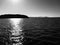 Black and white shot - Rugged rock formations emerge from the sea in Milos, an island in the sun - GREECE - MILOS