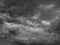 Black white sky with clouds. Dramatic cloudy sky background for design. Dark gray cloudscape.