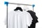 Black and white T-shirts on hangers on metal rack isolated on white