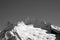 Black and white view from ski slope on snowy glacier and high mountain peaks