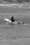 Black and White Woman Paddling a Surfboard