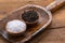 Black whole peppercorns and blue crystal salt in wooden bowls on an old flour shovel