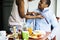 Black wife helping husband dress up during breakfast