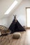 Black wigwam and knitted furniture in white walls living room