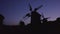 Black windmills silhouette at night.